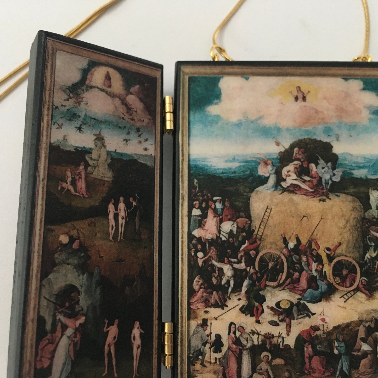 Triptych miniature art necklace handmade from sustainable wood reproduce The Haywain painting by Hieronymus Bosch. This aesthetic fully functioning art pendant necklace is created and designed by Obljewellery