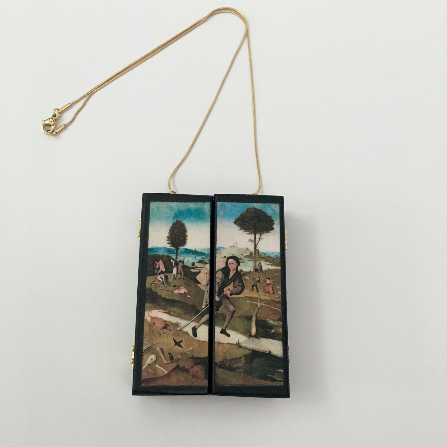Triptych miniature art necklace handmade from sustainable wood reproduce The Haywain painting by Hieronymus Bosch. This aesthetic fully functioning art pendant necklace is created and designed by Obljewellery