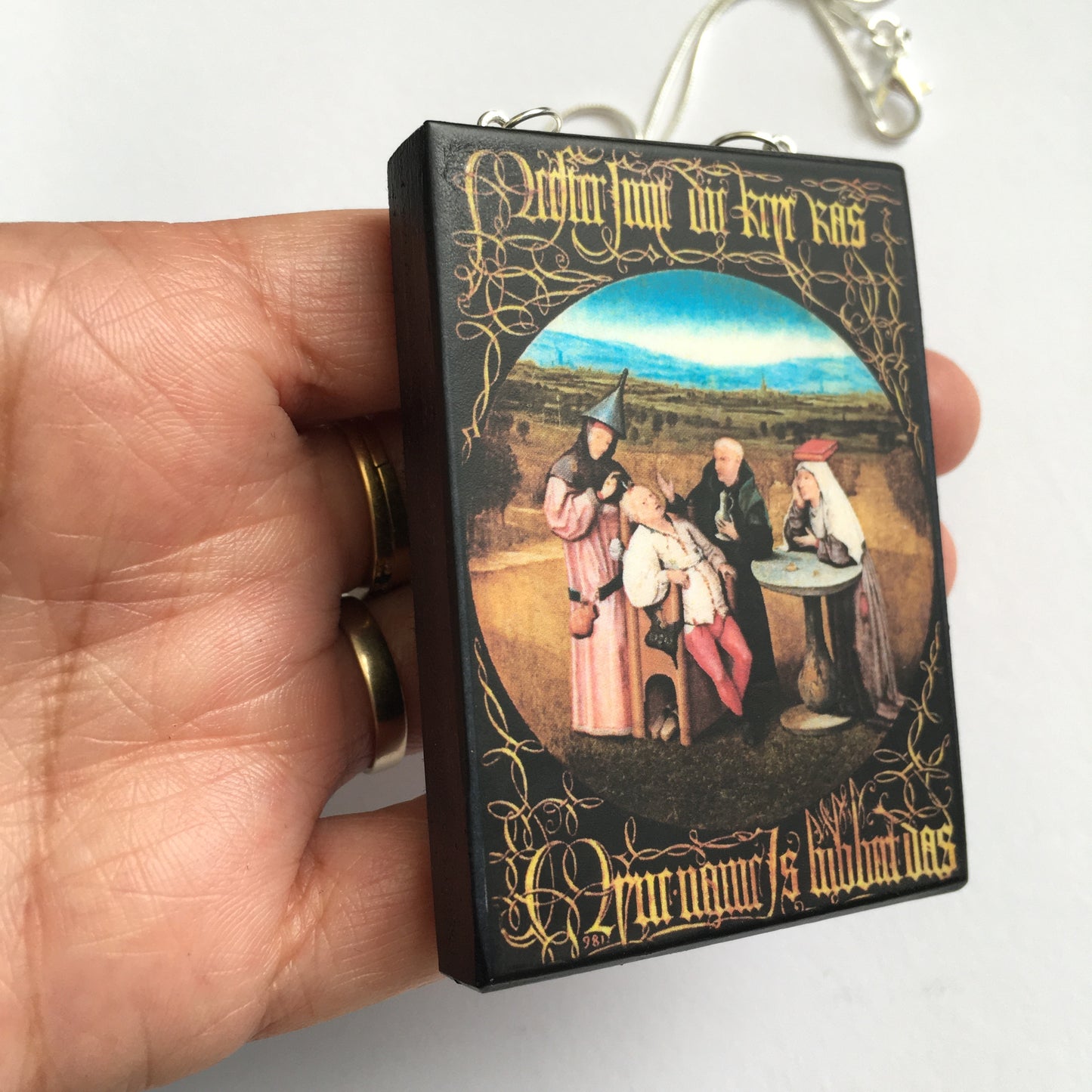 Hieronymus Bosch painting Cutting the Stone on top of this sustainable wood pendant with 925 sterling silver snake chain.