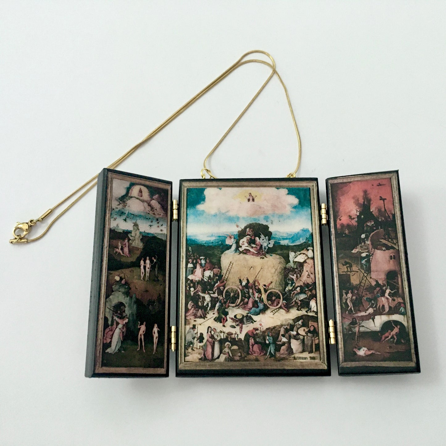 Triptych miniature art necklace handmade from sustainable wood reproduce The Haywain painting by Hieronymus Bosch. This aesthetic fully functioning art pendant necklace is created and designed by Obljewellery