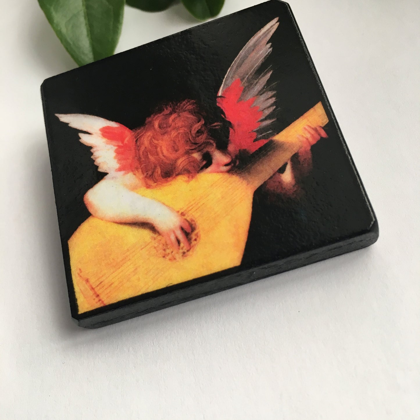 Obljewellery brooch with an angel playing mandolin. The angel has red and white wing .