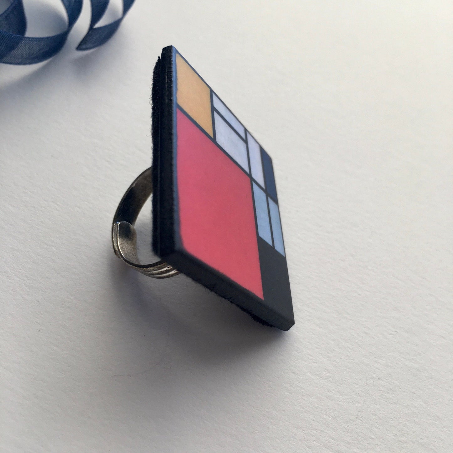 Wooden, 3.5 cm squared geometric art ring in red, blue, yellow and white colors. Obljewellery shop is inspired by Mondrian's De Stijl period works.