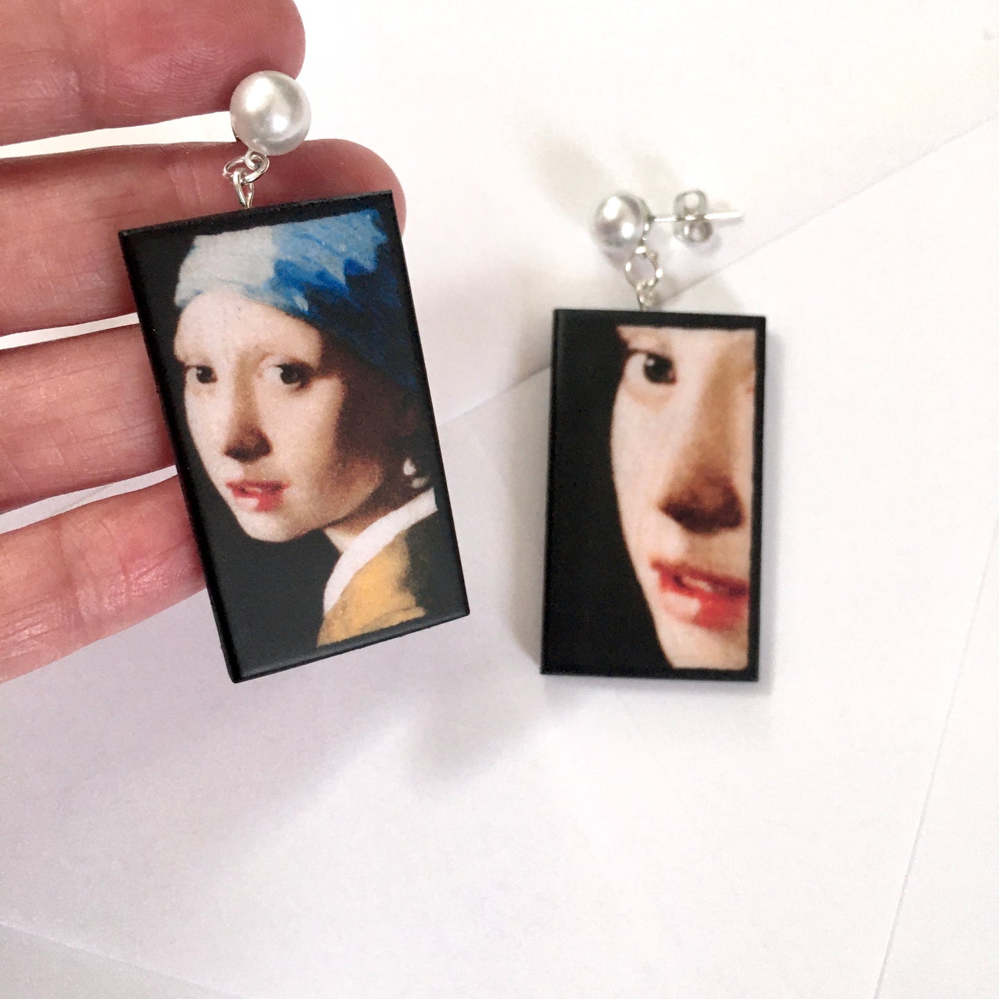 The girl with a pearl earring is a painting by Vermeer. These art details earring show the face of the girl they are in sustainable weood and have the stud earrings with pearls. Handmade mismatched earrings by Obljewellery