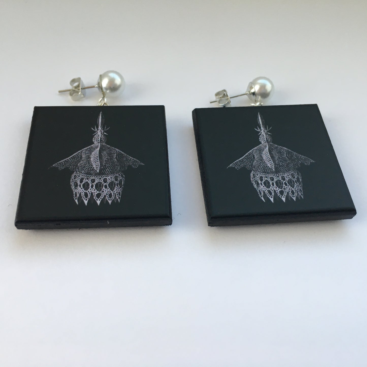 Sustainable wood earrings with stud pearls inspired by Ernst Haeckel marine shells, radiolaria black and white illustration. These earrings are completely handmade by Obljewellery