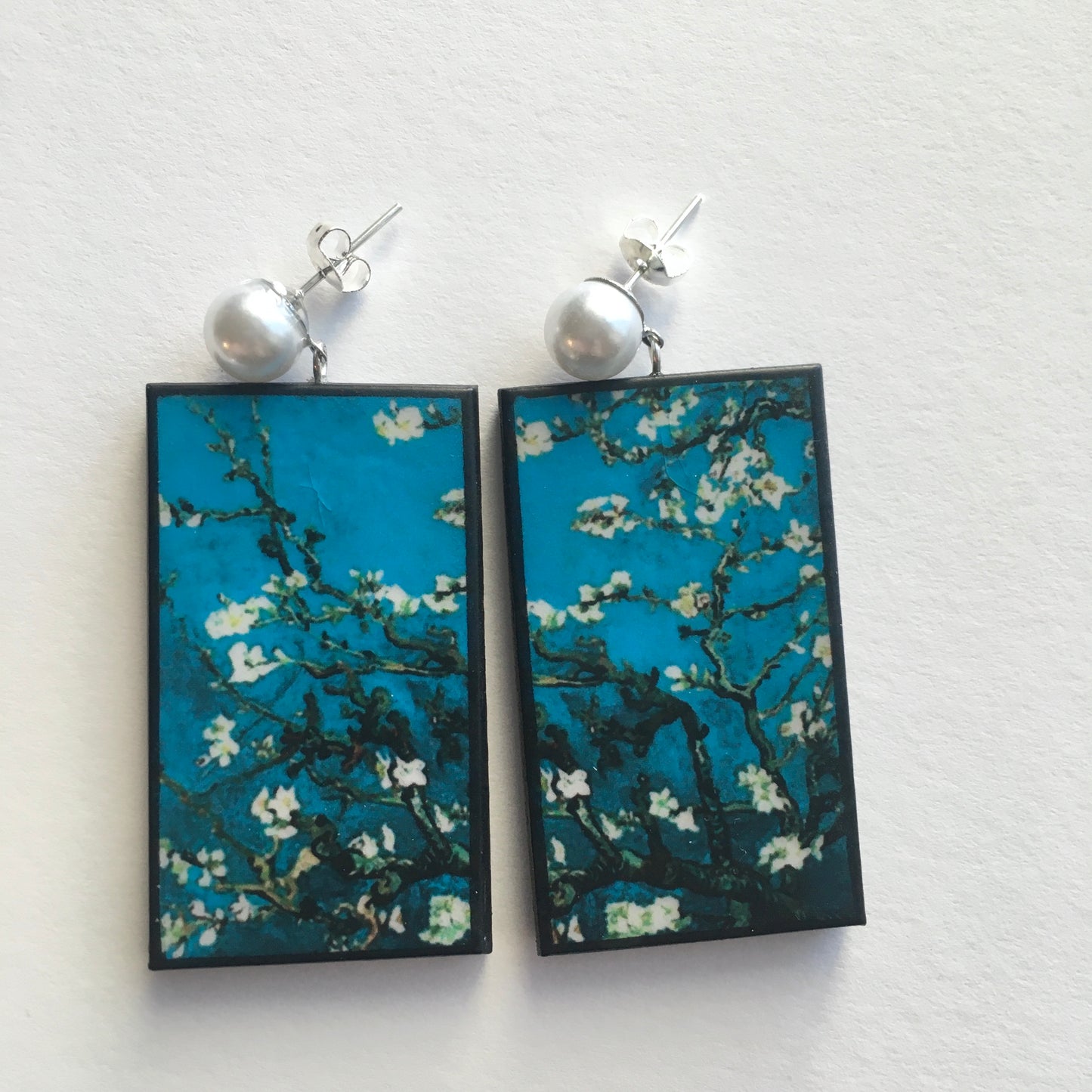 Stud pearls earrings with an art detail of the painting Almond Blossom by Vincent Van Gogh. These rectangular, turquoise background earrings are handmade from sustainable wood by Obljewellery.
