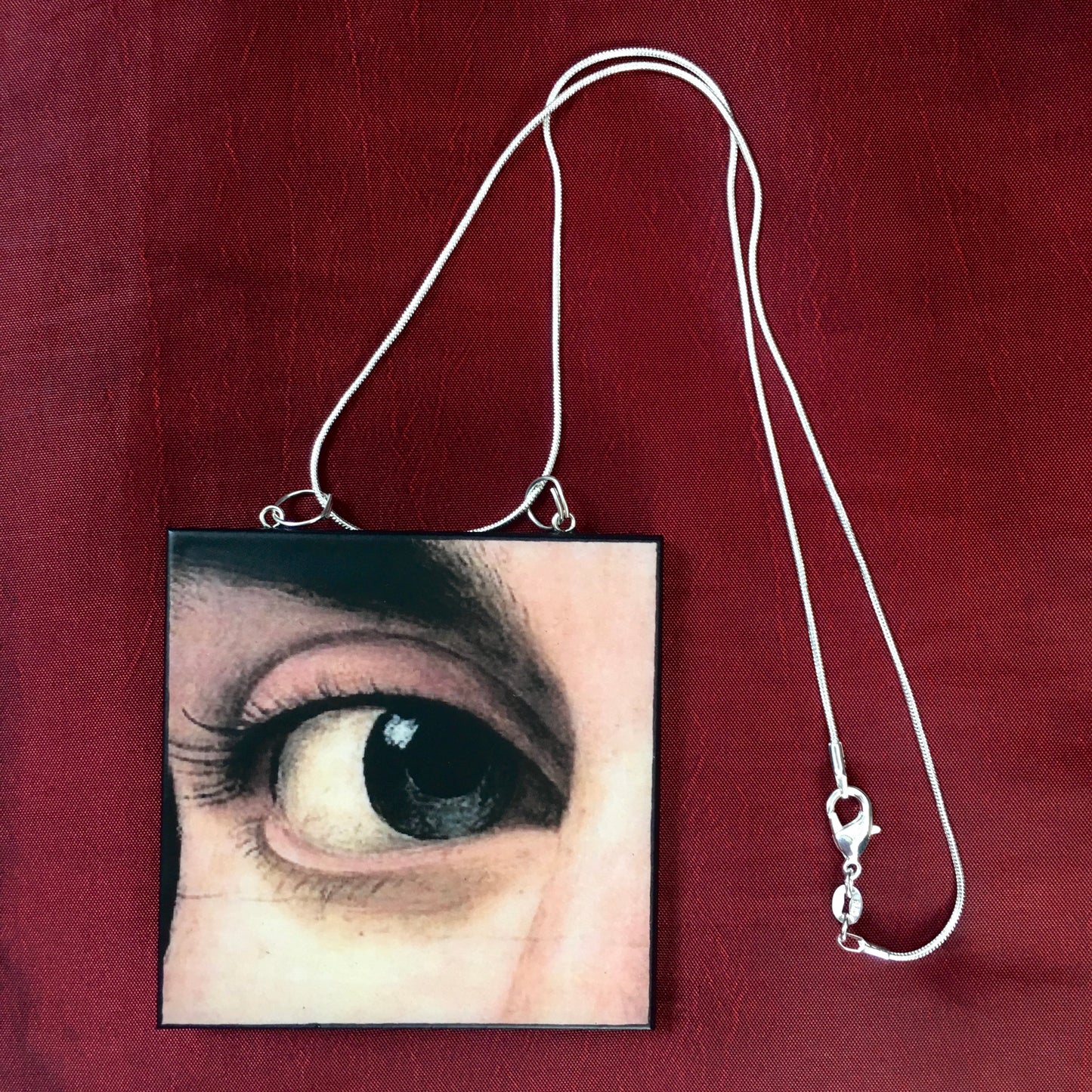 Sustainable wood pendant with an eye detail taken from a Renaissance art painting by Antonello da Messina. Handmade by Obljewellery
