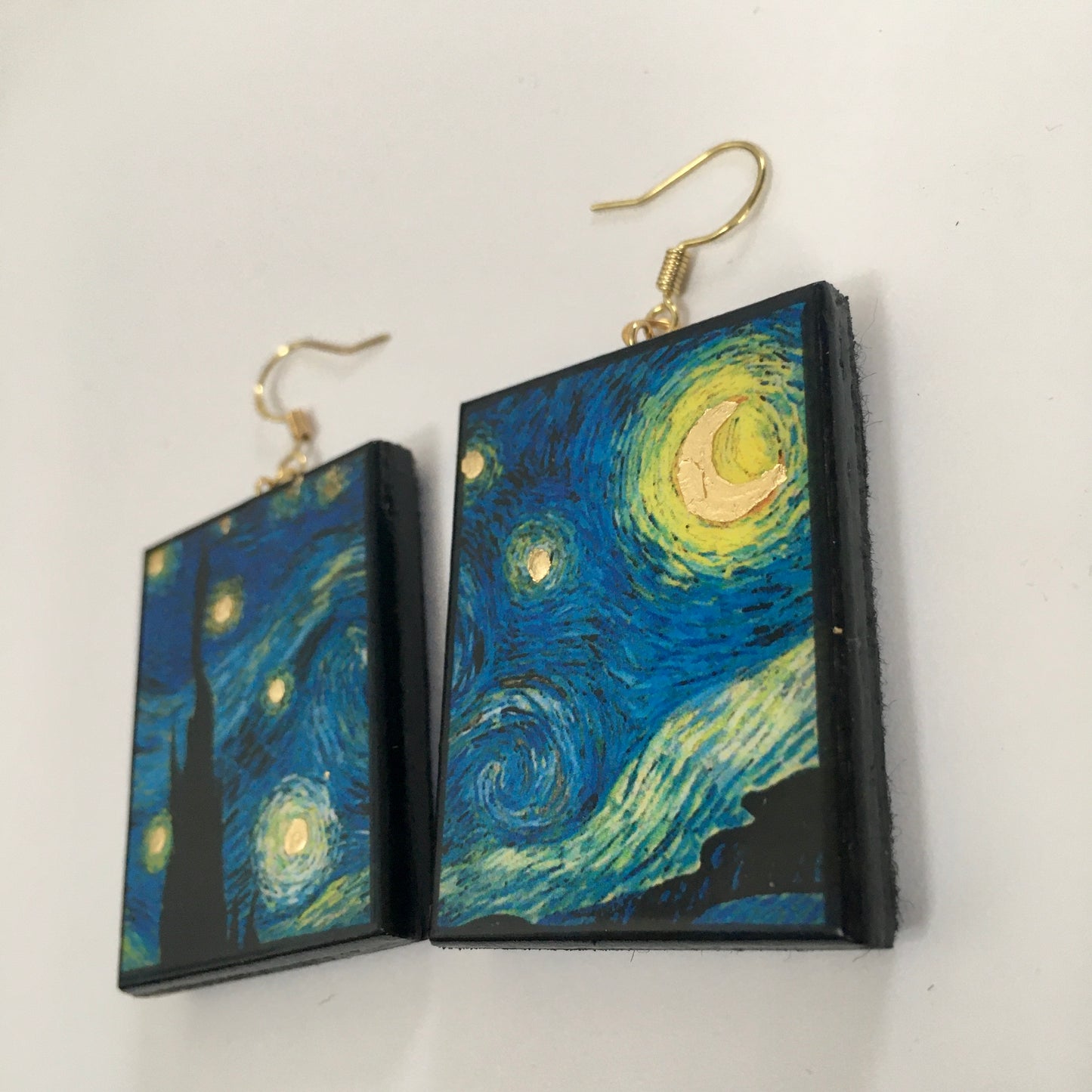Earrings shaped rectangular with some art details in gold leaf inspired by Vincent Van Gogh's "Starry Night" painting. Blue sky and gold little stars dangle earrings in sustainable wood. Handmade by Obljewellery