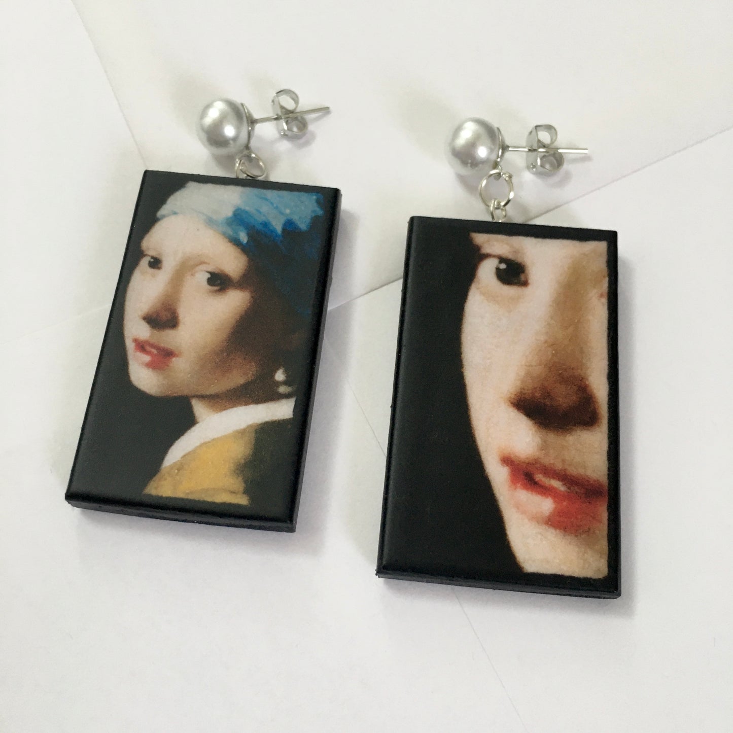 The girl with a pearl earring is a painting by Vermeer. These art details earring show the face of the girl they are in sustainable weood and have the stud earrings with pearls. Handmade mismatched earrings by Obljewellery