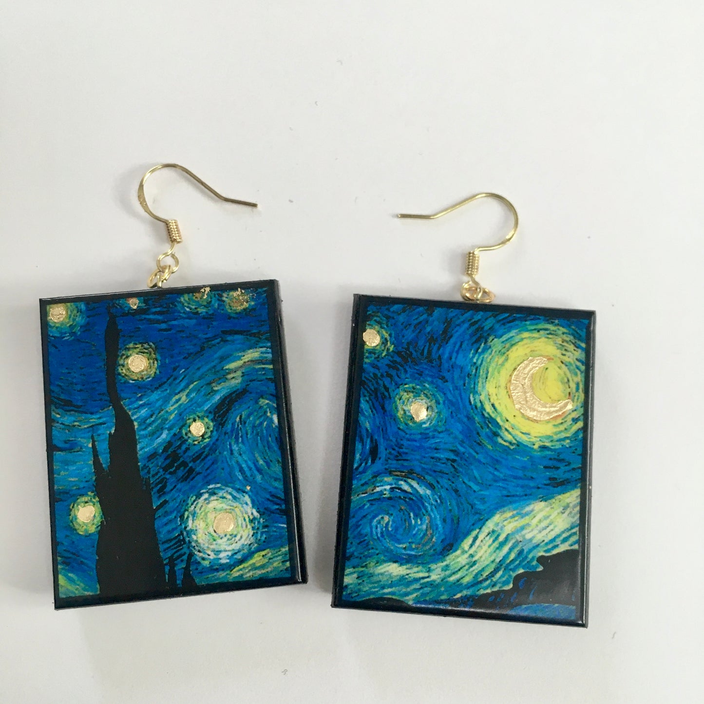 Earrings shaped rectangular with some art details in gold leaf inspired by Vincent Van Gogh's "Starry Night" painting. Blue sky and gold little stars dangle earrings in sustainable wood. Handmade by Obljewellery