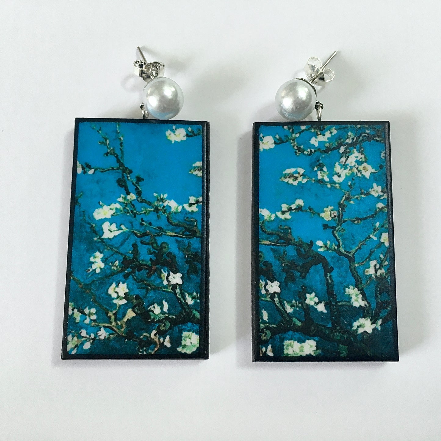 Stud pearls earrings with an art detail of the painting Almond Blossom by Vincent Van Gogh. These rectangular, turquoise background earrings are handmade from sustainable wood by Obljewellery.