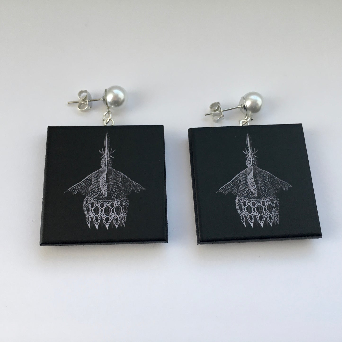 Sustainable wood earrings with stud pearls inspired by Ernst Haeckel marine shells, radiolaria black and white illustration. These earrings are completely handmade by Obljewellery
