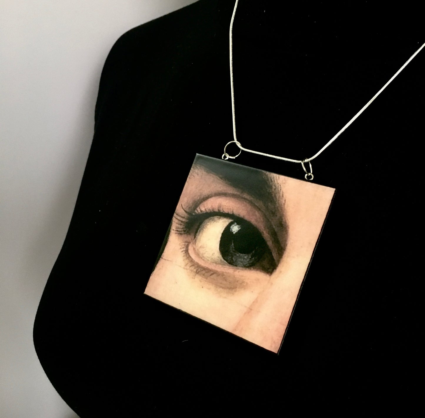 Sustainable wood pendant with an eye detail taken from a Renaissance art painting by Antonello da Messina. Handmade by Obljewellery