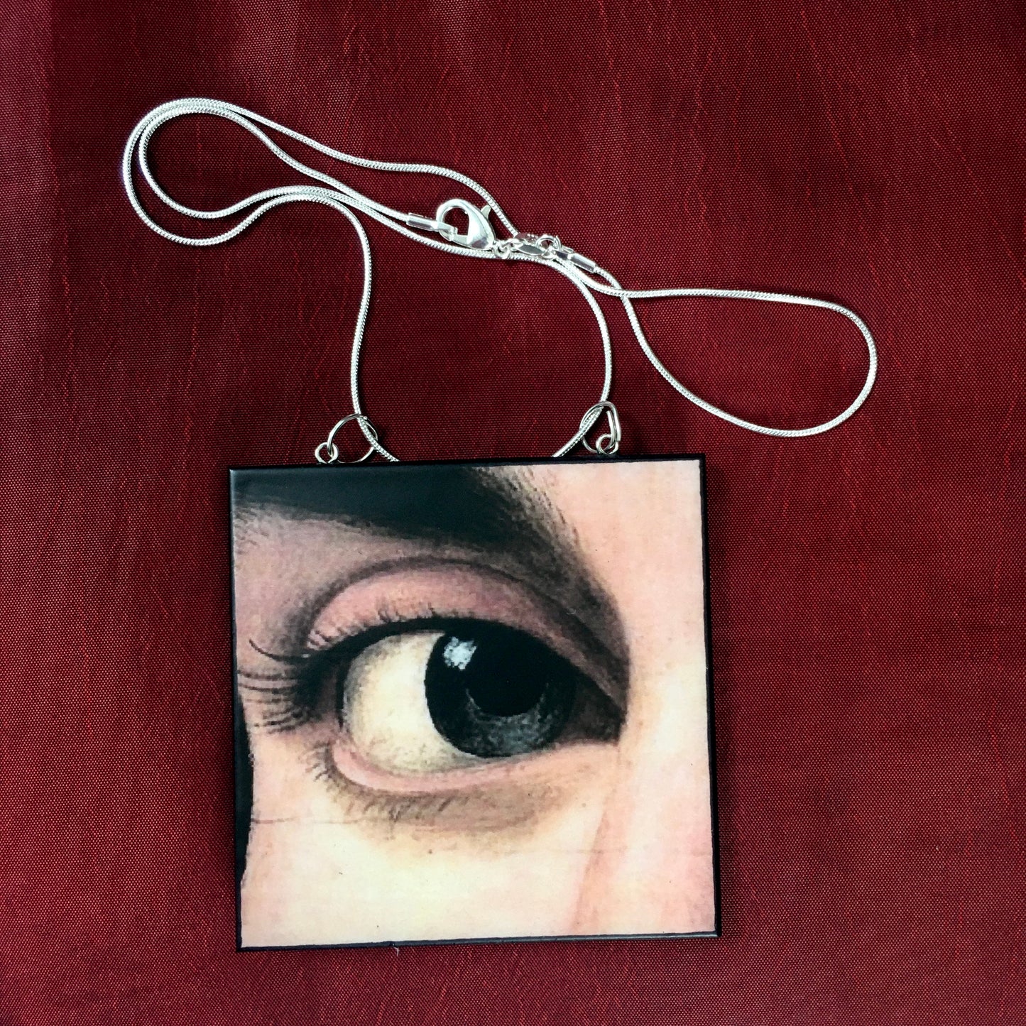 Sustainable wood pendant with an eye detail taken from a Renaissance art painting by Antonello da Messina. Handmade by Obljewellery