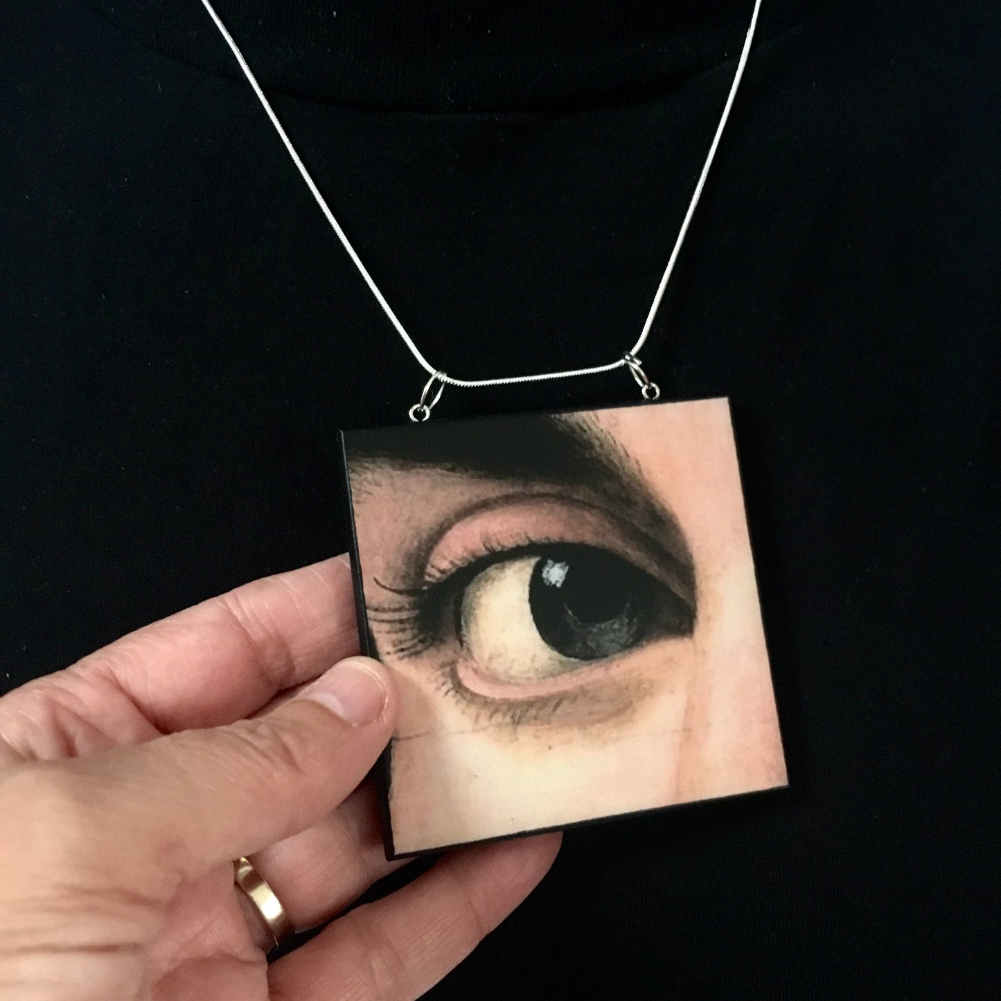 Sustainable wood pendant with an eye detail taken from a Renaissance art painting by Antonello da Messina. Handmade by Obljewellery