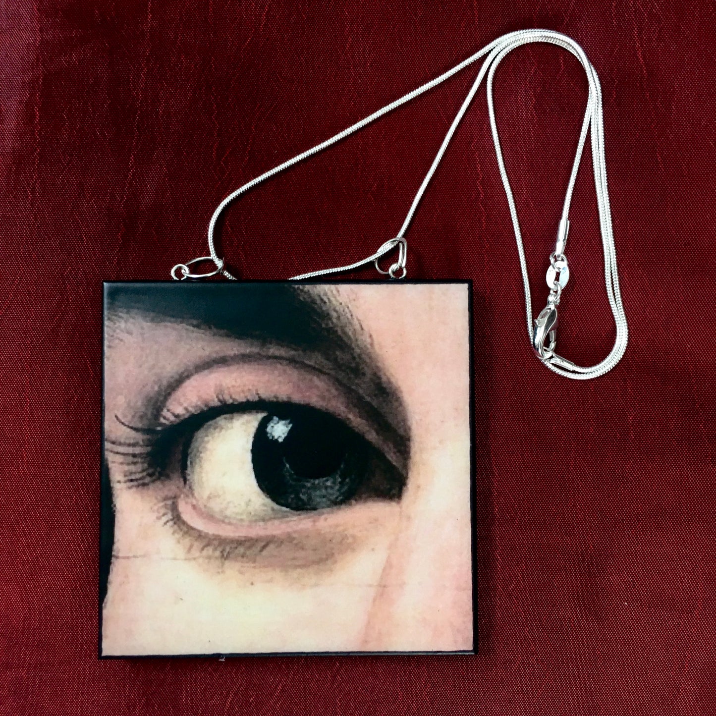 Sustainable wood pendant with an eye detail taken from a Renaissance art painting by Antonello da Messina. Handmade by Obljewellery
