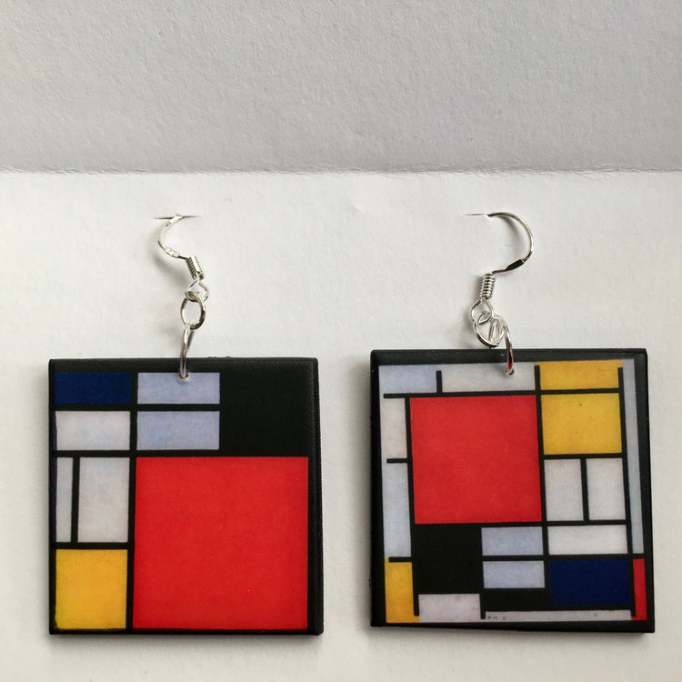 De stijl, Mondrian inspired earrings are wearable art earrings handmade by Obljewellery. Primary colours, blue, yellow and red are used in abstract, geometric shapes.
