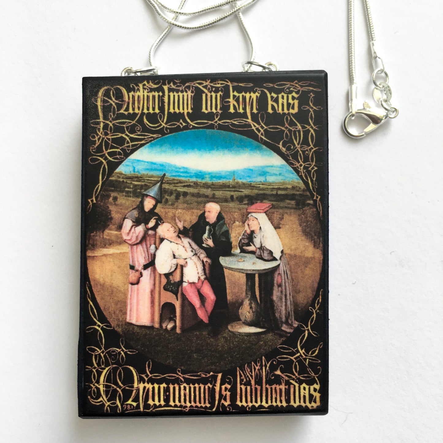 Hieronymus Bosch painting Cutting the Stone on top of this sustainable wood pendant with 925 sterling silver snake chain.