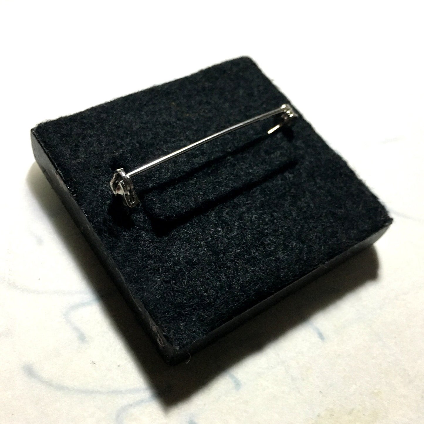 back side of the wooden brooch pin covered with black felt