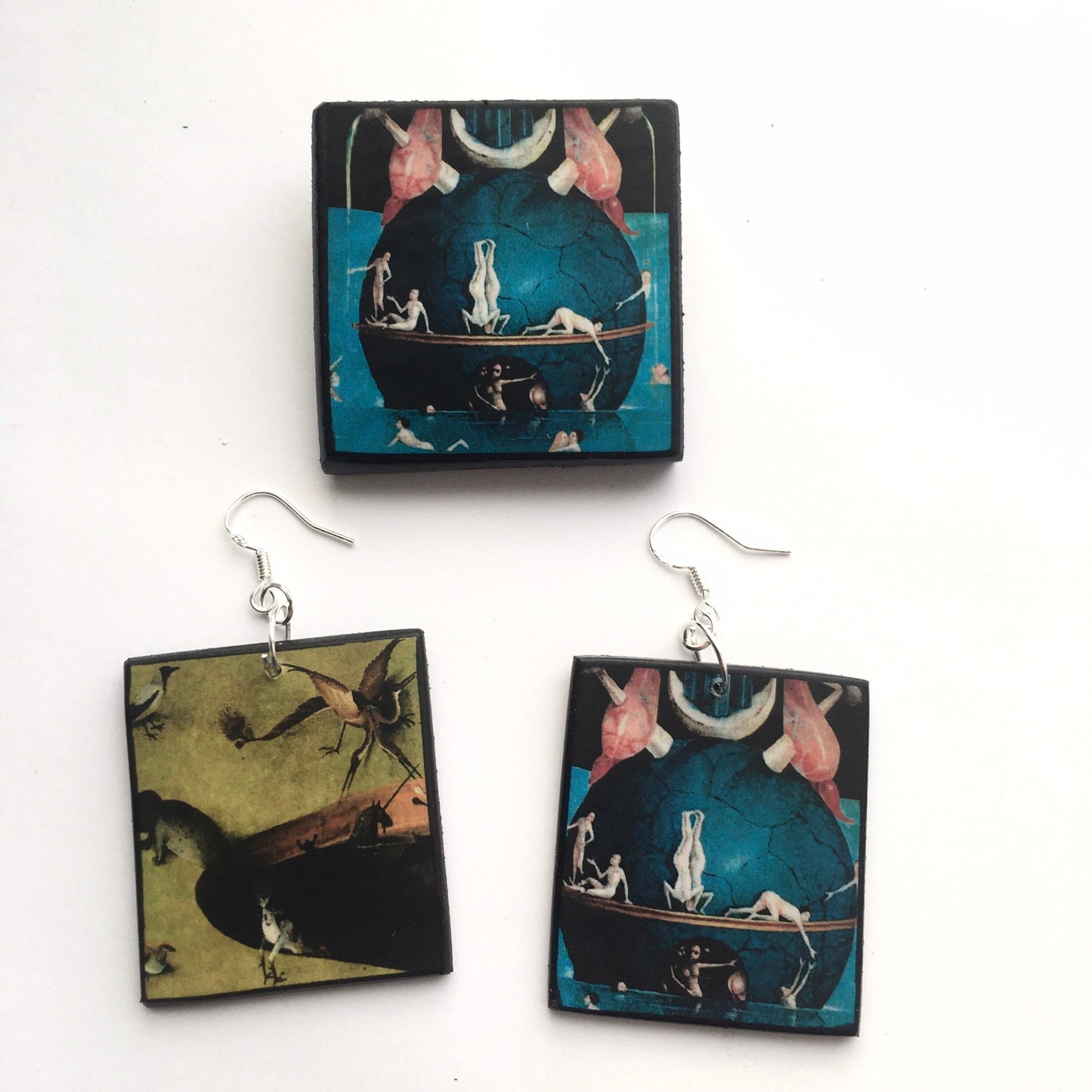 Set of mismatched earrings and one brooch based on Hieronymus Bosch art.