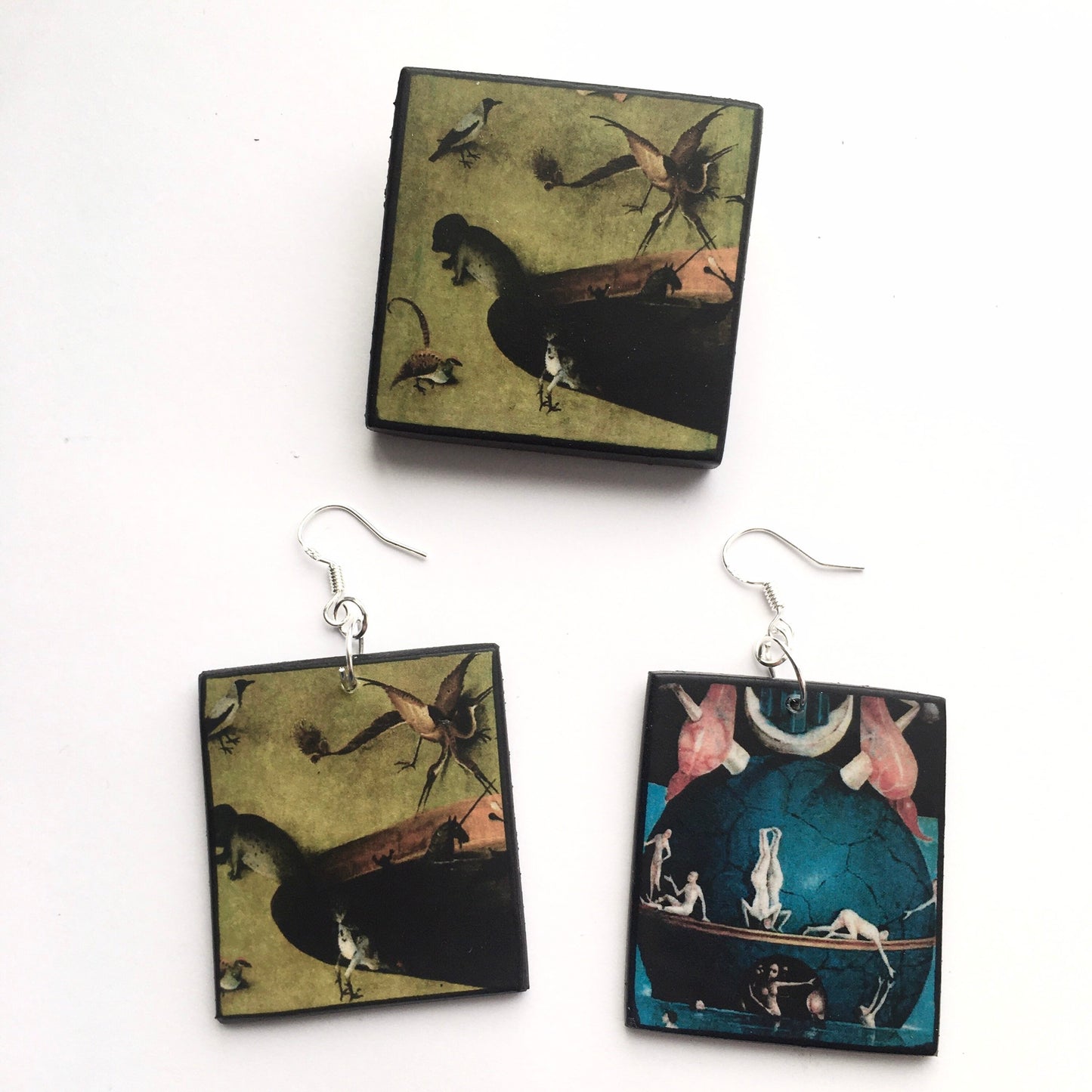 Set of mismatched earrings and one brooch based on Hieronymus Bosch art.