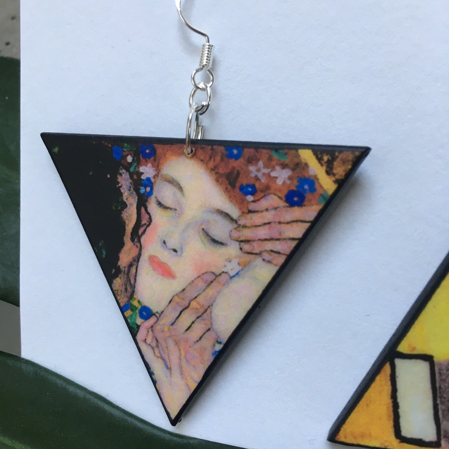 Triangular wood earring with a detail of the Klimt painting The Kiss. Obljewellery shop earrings