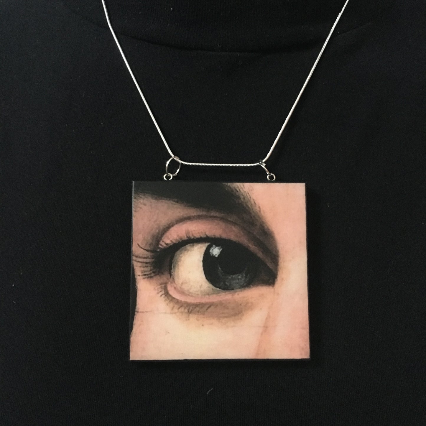 Sustainable wood pendant with an eye detail taken from a Renaissance art painting by Antonello da Messina. Handmade by Obljewellery