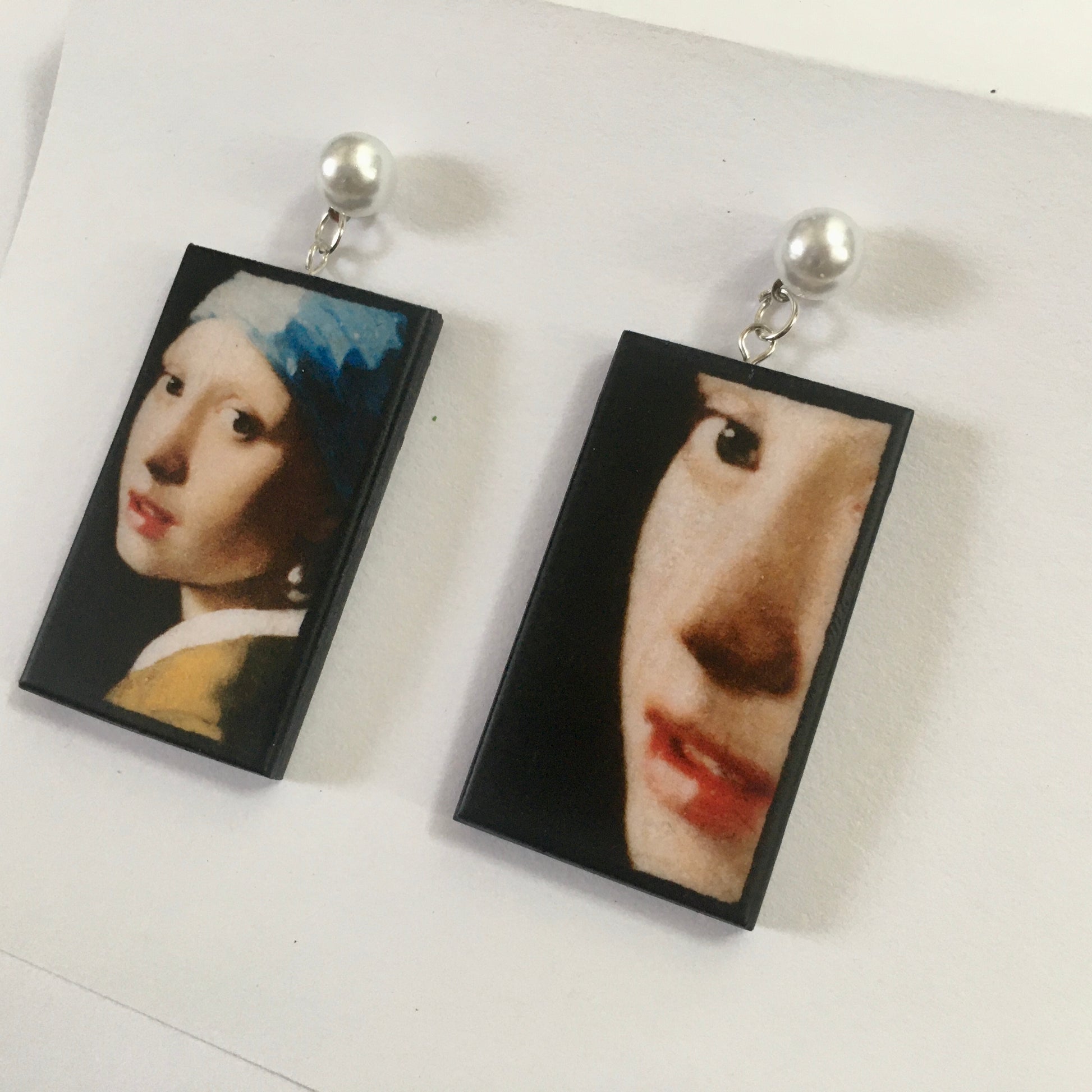 The girl with a pearl earring is a painting by Vermeer. These art details earring show the face of the girl they are in sustainable weood and have the stud earrings with pearls. Handmade mismatched earrings by Obljewellery