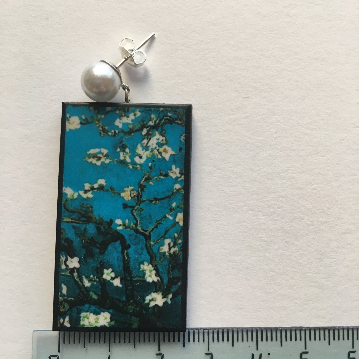 Stud pearls earrings with an art detail of the painting Almond Blossom by Vincent Van Gogh. These rectangular, turquoise background earrings are handmade from sustainable wood by Obljewellery.
