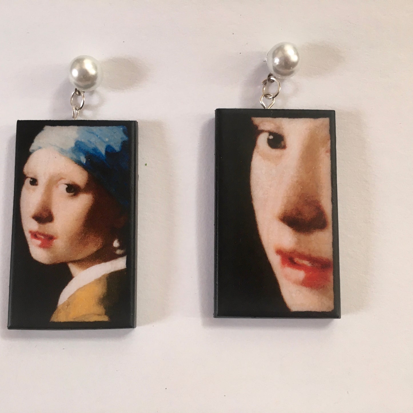 The girl with a pearl earring is a painting by Vermeer. These art details earring show the face of the girl they are in sustainable weood and have the stud earrings with pearls. Handmade mismatched earrings by Obljewellery