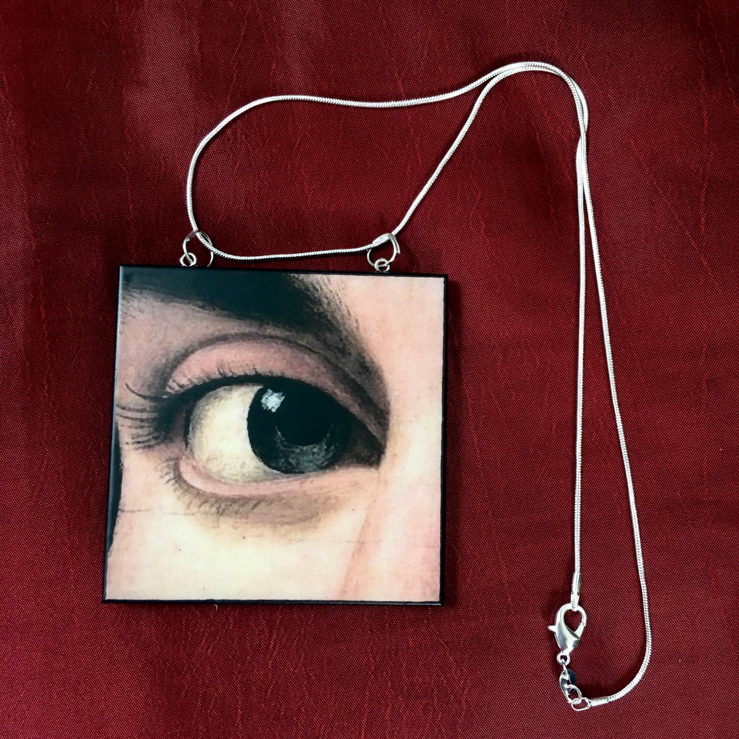 Sustainable wood pendant with an eye detail taken from a Renaissance art painting by Antonello da Messina. Handmade by Obljewellery