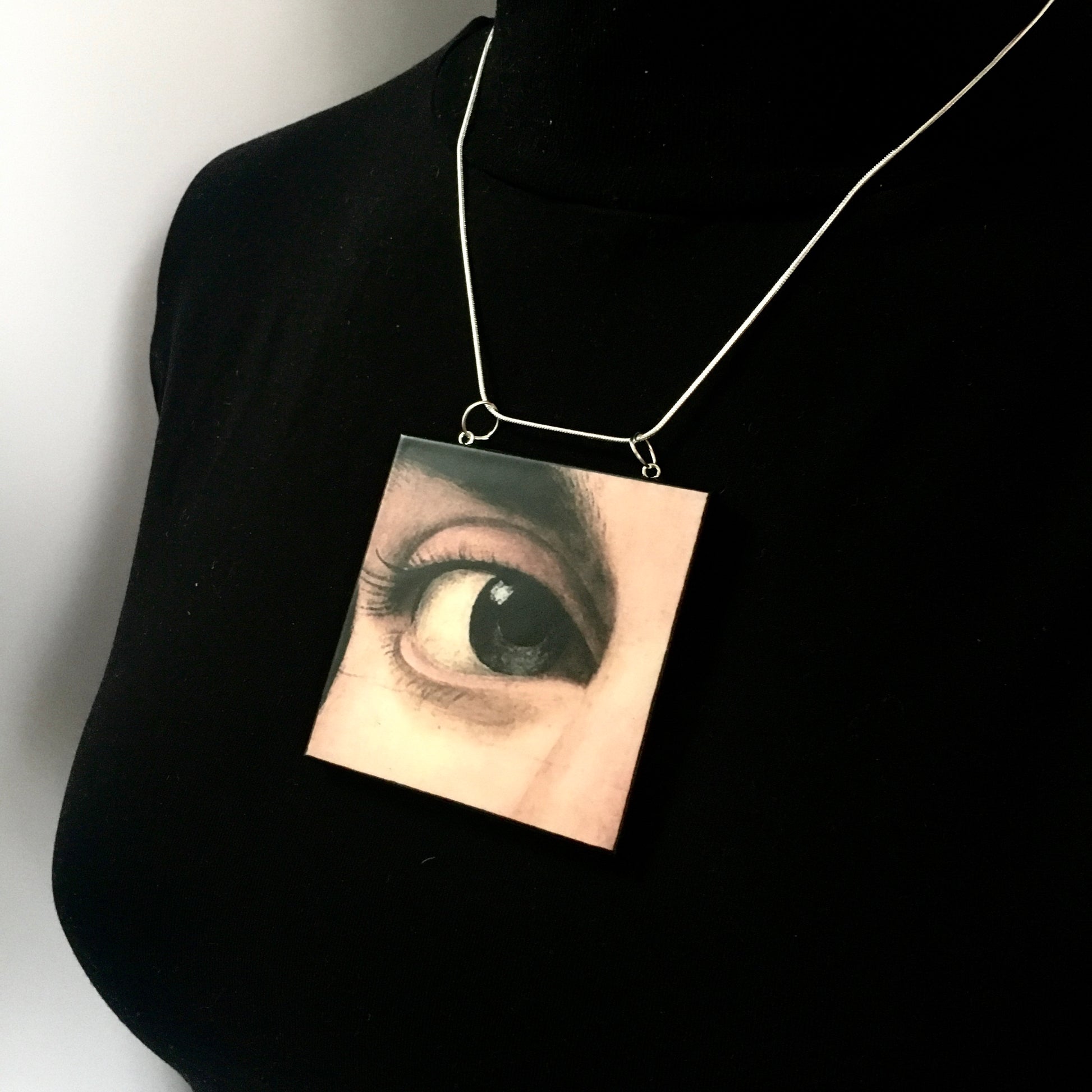 Sustainable wood pendant with an eye detail taken from a Renaissance art painting by Antonello da Messina. Handmade by Obljewellery