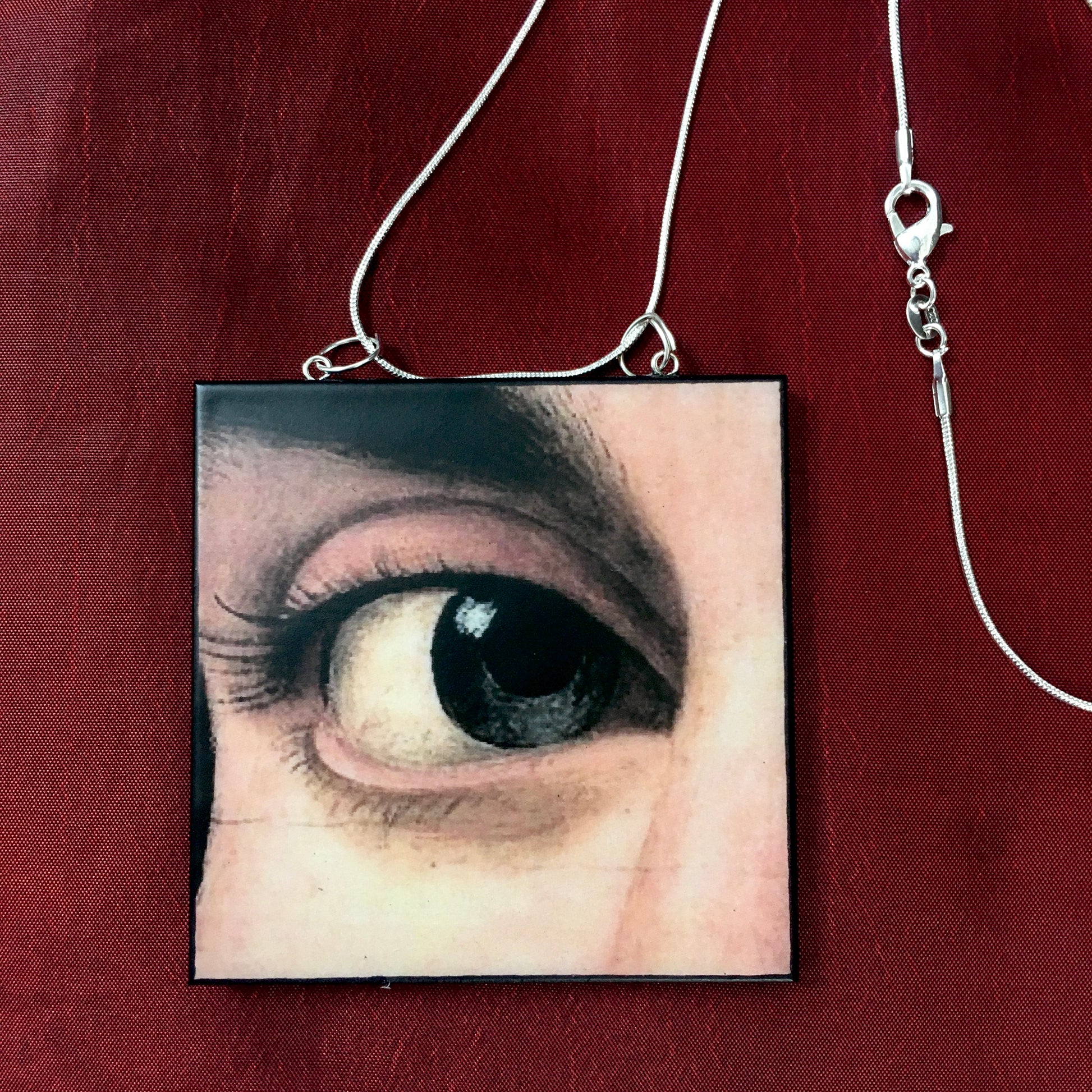 Sustainable wood pendant with an eye detail taken from a Renaissance art painting by Antonello da Messina. Handmade by Obljewellery