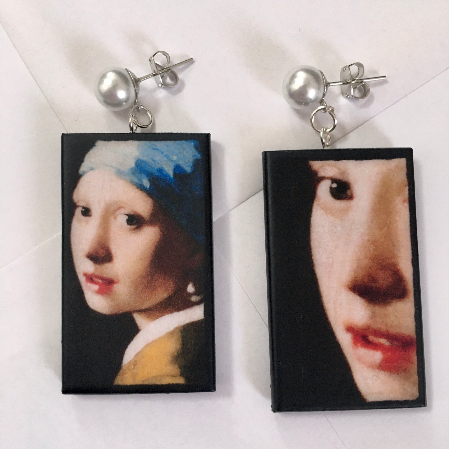 The girl with a pearl earring is a painting by Vermeer. These art details earring show the face of the girl they are in sustainable weood and have the stud earrings with pearls. Handmade mismatched earrings by Obljewellery