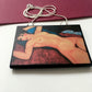 Amedeo Modigliani necklace handmade from sustainable wood by Obljewellery. The statement rectangular pendant with the painting of the nude female reclining on a red sofa on the blue cushion.