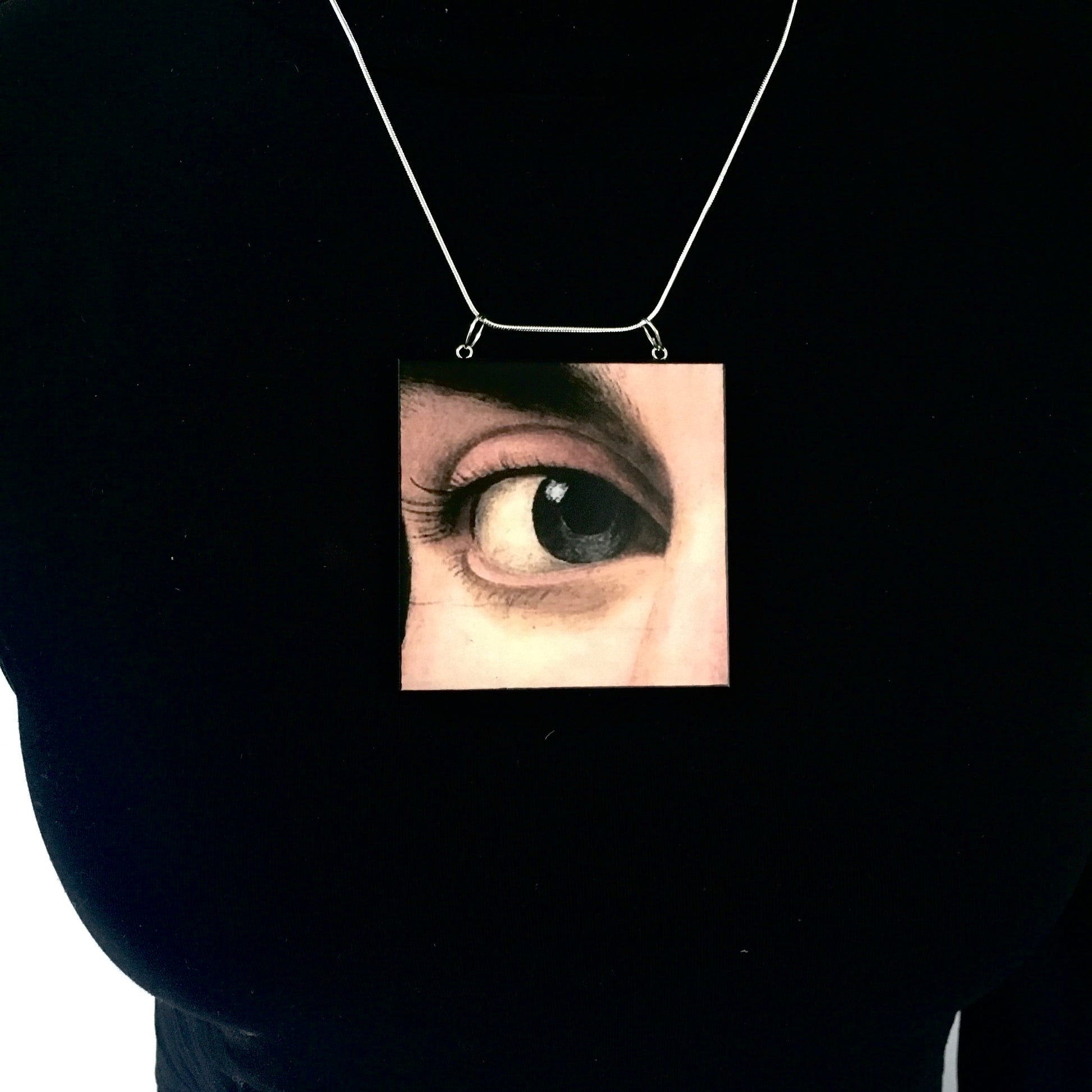 Sustainable wood pendant with an eye detail taken from a Renaissance art painting by Antonello da Messina. Handmade by Obljewellery