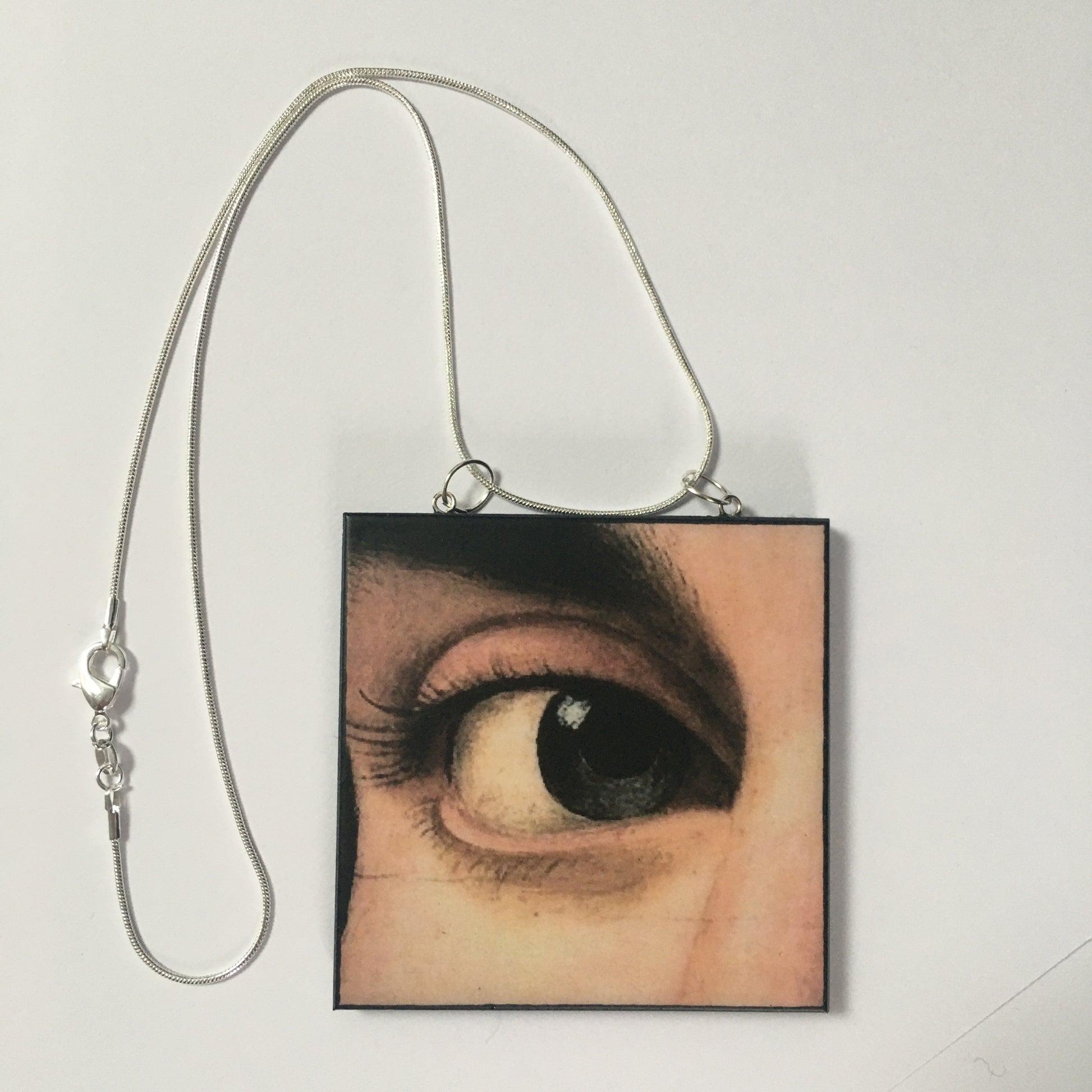 Sustainable wood pendant with an eye detail taken from a Renaissance art painting by Antonello da Messina. Handmade by Obljewellery